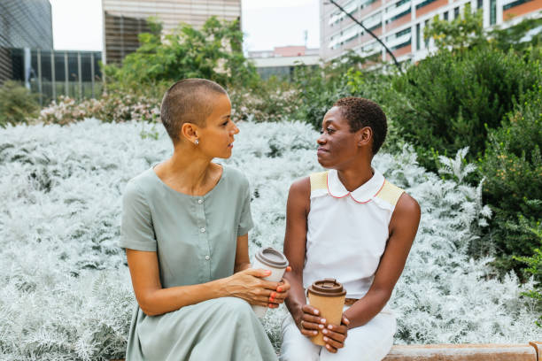istock Two Friends Sharing a Moment Over Coffee in a Lush Park 2176713138