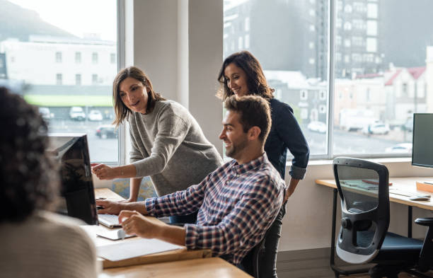 istock Group of diverse young designers working on a computer together 2176713215