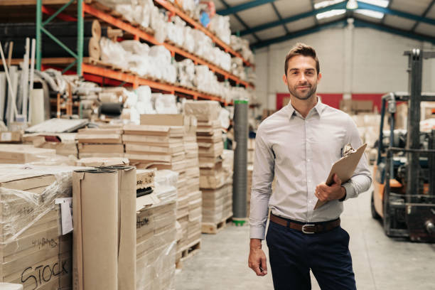 istock Smiling manager standing in his warehouse with a clipboard 2176718397