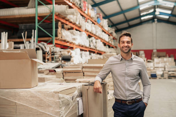 istock Manager smiling while leaning against stock in a large warehouse 2176719471