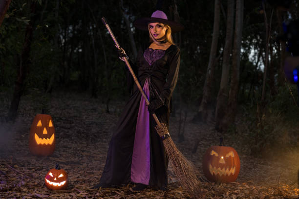 istock A charming  witch  with a carved pumpkin  and magic pot with smoke on Halloween night 2176720865