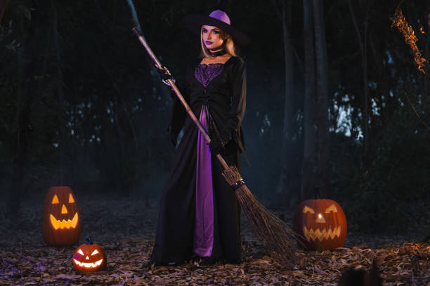 istock A charming  witch  with a carved pumpkin  and magic pot with smoke on Halloween night 2176720916