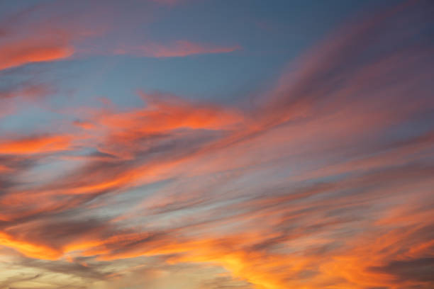 Sunset sky background with golden orange clouds on a blue skyscape backdrop