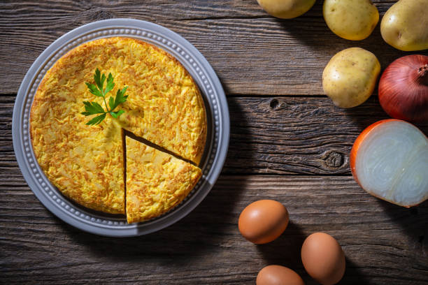 istock Traditional Spanish omelette with potatoes and onions on rustic wooden tabletop 2176723808