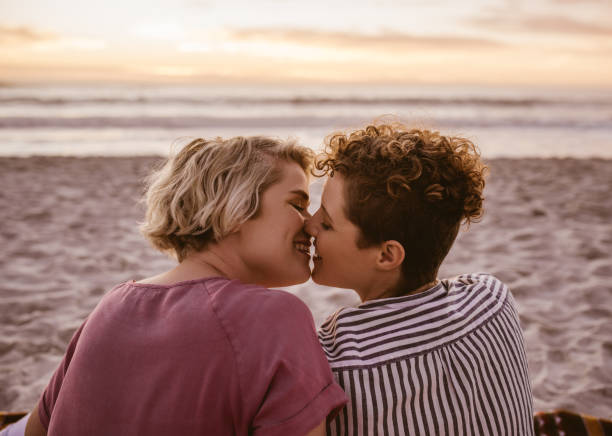 istock Romantic young lesbian couple kissing during a beach sunset 2176725215