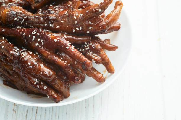 Caramelized korean or Chinese chicken foots ( paws ) with sesame . Top view photography