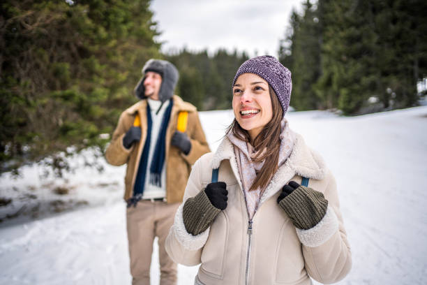 Young cheerful woman enjoying while walking in the snow covered mountain