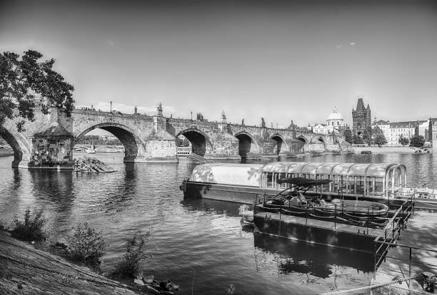 Charles Bridge crossing the Vltava River on a sunny day with the buildings of old town in the background in Prague, Czech Republic