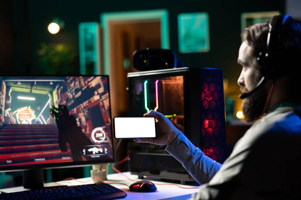 istock Gamer learning online multiplayer shooter tips from video on mockup phone 2176737923