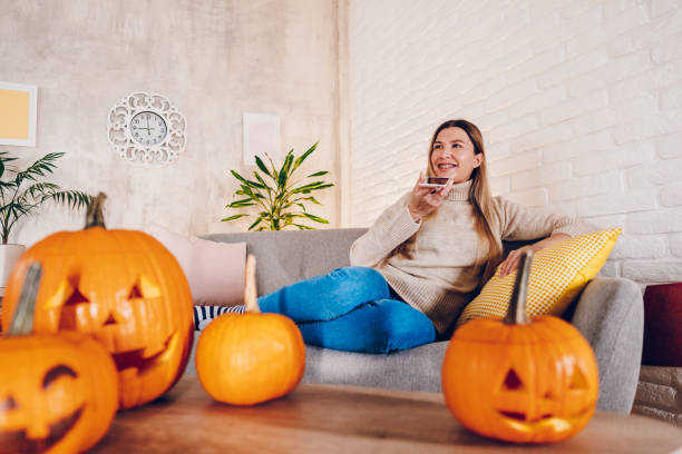 istock A young woman  sends a voice message while enjoying at home for Halloween 2176739759