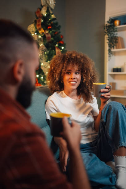 istock Couple relaxing on sofa drinking coffee by christmas tree 2176748927