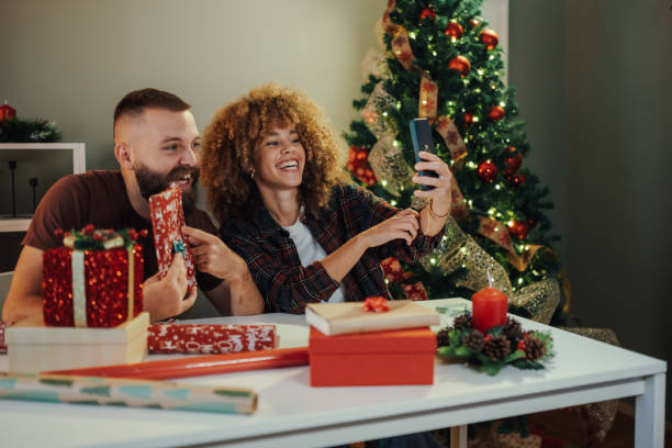 istock Happy couple taking selfie while wrapping christmas presents 2176748994