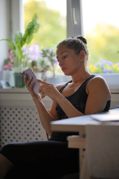 istock A Young Woman is Engaged with Her Smartphone While in a Stylish Modern Kitchen Setting 2176753249