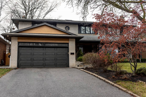 Luxurious home exterior with blue vinyl siding and white trim. Long concrete driveway lead to three attached garage spaces. Beautiful curb appeal. Northwest, USA