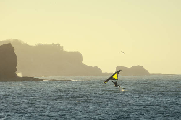 Windsurfer at sunny windy day against the backdrop of coastal cliffs. Scotland