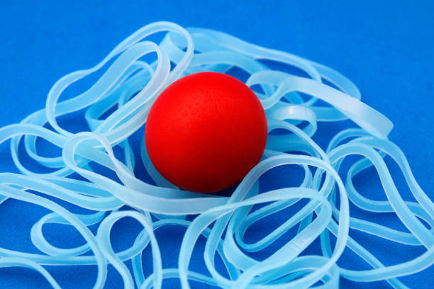 istock Red sphere surrounded by several problems represented with a group of rubber bands 2176778935