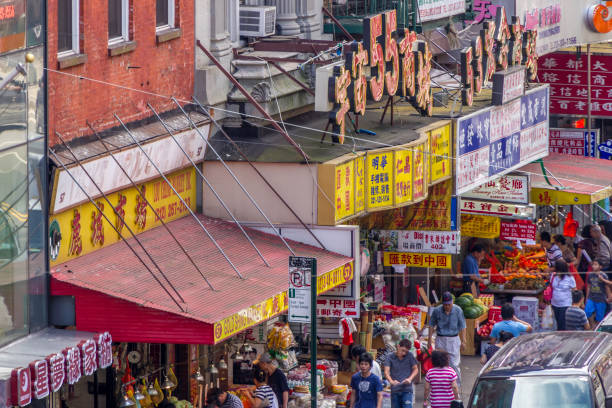 NYC, NY USA Aug 29, 2013: Shoppers crowd the sidewalks of East Broadway in Chinatown, as seen from the elevated viewpoint of the Manhattan Bridge Pedestrian Path.