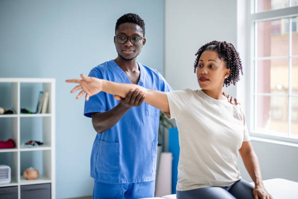istock Therapist aids patient with arm movement exercise. 2176790889