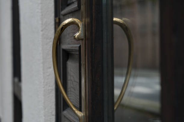 Tall brass door handle and its reflection in a restaurant door at Christiania Torv, Oslo, Norway