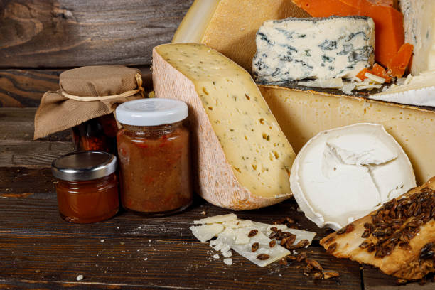 A beautiful Artisan Cheeses and Jams Display arranged elegantly on a Rustic Wooden Table