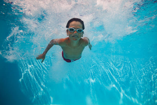 istock Kid boy with goggles swimming underwater joyfully after dive 2176798048