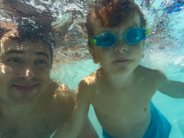 istock Two smiling swimmers, father and son make underwater selfie 2176798176