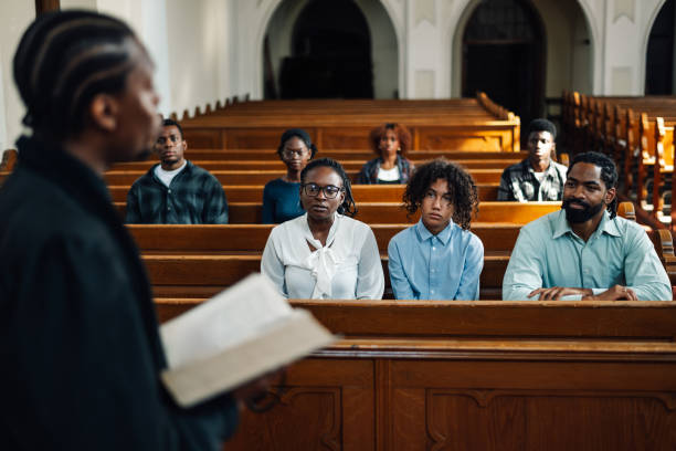 istock African american priest leading congregation in prayer at church 2176799521