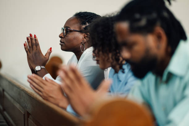 istock Group of people praying inside a church 2176799533