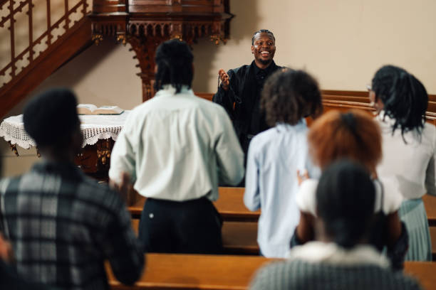 istock Pastor leading congregation in prayer inside church 2176799548