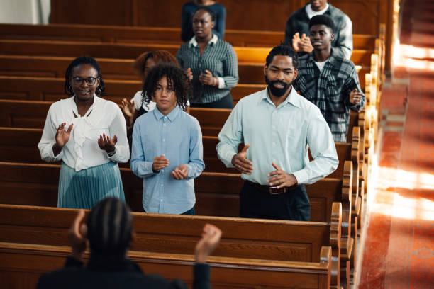 istock Congregation standing and praying together in church pew 2176799566