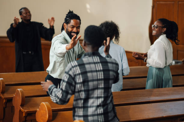 Group of people celebrating faith inside a church Diverse group of people celebrating their faith in a beautiful church, singing songs of praise and praying together, united in spirituality and love for god and jesus black gospel church stock pictures, royalty-free photos & images