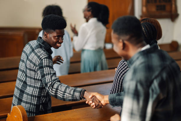 istock Two men shaking hands during church service with congregation in background 2176799574