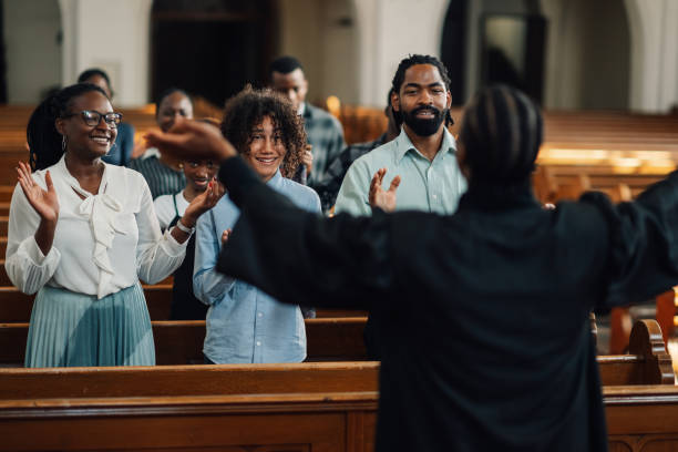 istock Preacher leading congregation in clapping during church service 2176799584