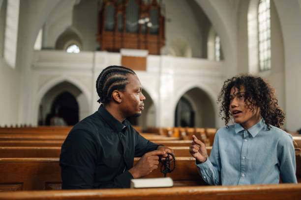 istock Priest listening to young man talking about problems in church 2176799600