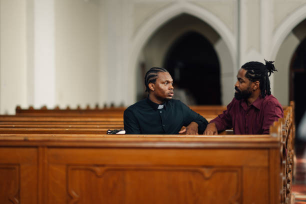 istock Priest listening to a man talking in church 2176799607