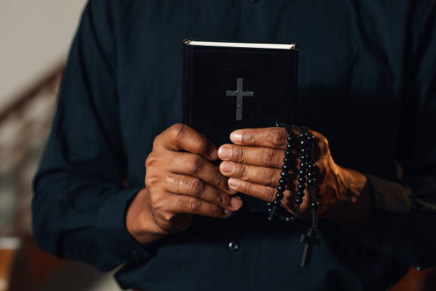 istock Priest praying holding holy bible and rosary beads 2176799644