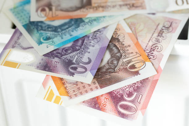 british pounds lying on radiator, Financial concept, household budget, bills expenses in uk british pounds lying on radiator, Financial concept, household budget, bills expenses in uk, close up british currency stock pictures, royalty-free photos & images