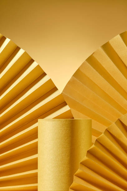 istock A yellow cardboard platform, surrounded by fan-shaped paper props, is placed in a bronze-colored frame with empty space for displaying a product, creating a luxurious atmosphere. 2176831307