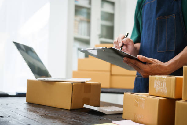 istock A man is working at his desk, preparing parcel boxes for shipment. He checks and packs items carefully, using shockproof materials, and attaches labels before sending them to customers via EMS. 2176862166