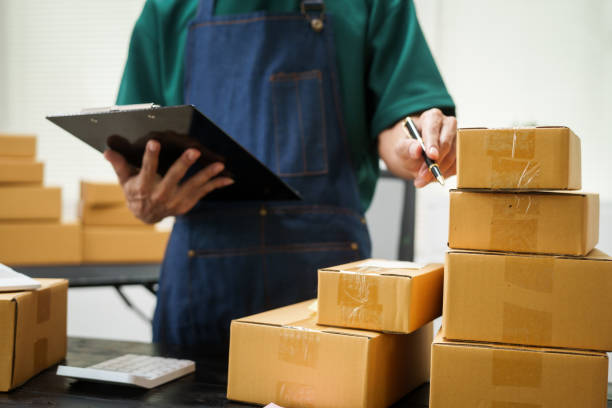 istock A man is working at his desk, preparing parcel boxes for shipment. He checks and packs items carefully, using shockproof materials, and attaches labels before sending them to customers via EMS. 2176862173