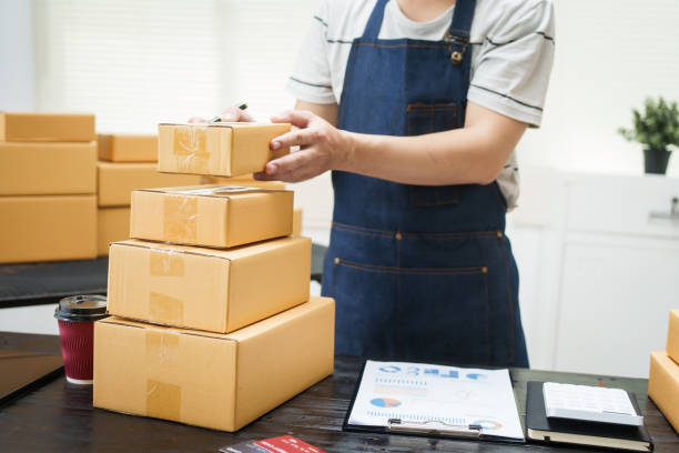 istock A man is working at his desk, preparing parcel boxes for shipment. He checks and packs items carefully, using shockproof materials, and attaches labels before sending them to customers via EMS. 2176862177