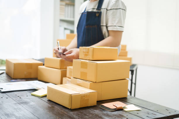 istock A man is working at his desk, preparing parcel boxes for shipment. He checks and packs items carefully, using shockproof materials, and attaches labels before sending them to customers via EMS. 2176862179