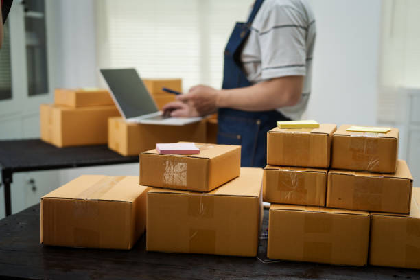 istock A man is working at his desk, preparing parcel boxes for shipment. He checks and packs items carefully, using shockproof materials, and attaches labels before sending them to customers via EMS. 2176862184