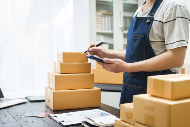 istock A man is working at his desk, preparing parcel boxes for shipment. He checks and packs items carefully, using shockproof materials, and attaches labels before sending them to customers via EMS. 2176862187