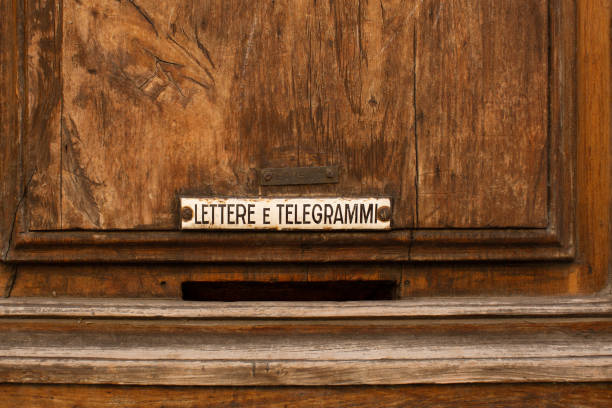 Letter and telegram delivery hole in an old weathered wooden door in Florence