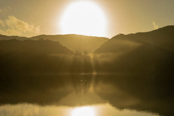 An abstract image of a peaceful moomaw lake in the evening. There are strange formations of clouds in the sunset sky.  The mountains (from the Gathright Wildlife Management Area) are rising up to meet the clouds.  It is part of  the George Washington and Jefferson National Forest. Copy space.