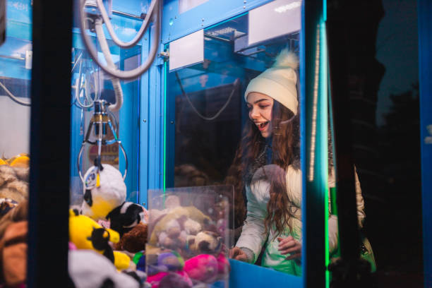 istock Young woman playing a claw machine in the arcade 2176877430