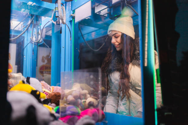 istock Young woman playing a claw machine in the arcade 2176877435