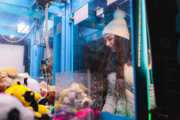 istock Young woman playing a claw machine in the arcade 2176877457