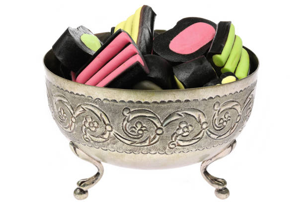 Finnish mixed licorice candies in a silver bowl isolated on white background